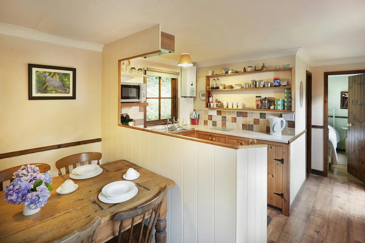 Kitchen area with dining room and dining table with tableware